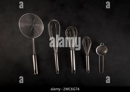 kitchen utensils on black background, seen from above. Stock Photo