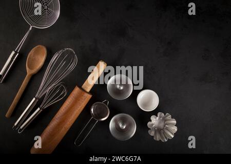 kitchen utensils on black background, seen from above. Stock Photo