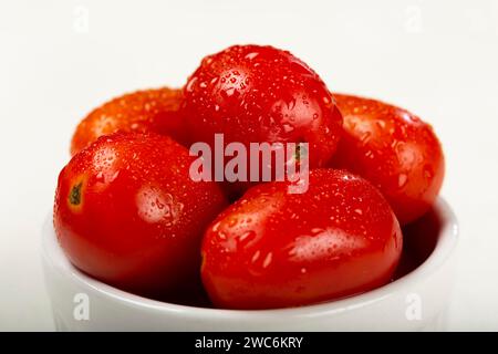 Fresh tomatoes on ramekin on white background. Stock Photo
