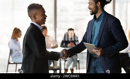 Two smiling black businessmen shaking hands after making good deal Stock Photo