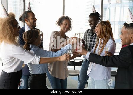 Overjoyed diverse colleagues having fun celebrate company party in office Stock Photo