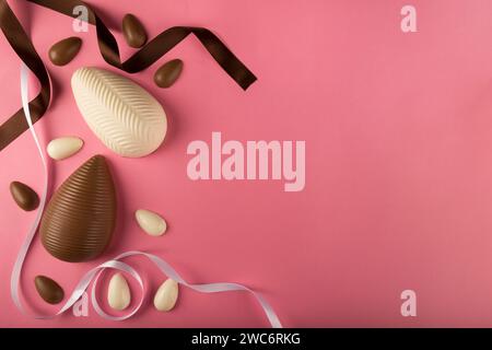 Easter. Composition with chocolate Easter eggs on pink background, space for text. Stock Photo