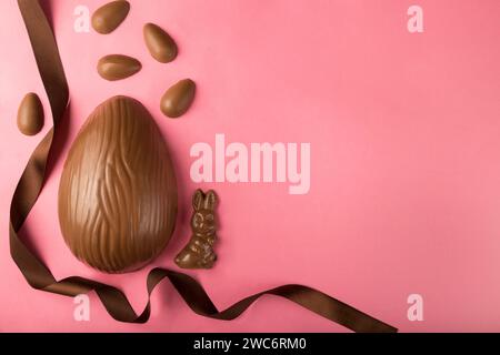 Easter. Composition with chocolate Easter eggs on pink background, space for text. Stock Photo