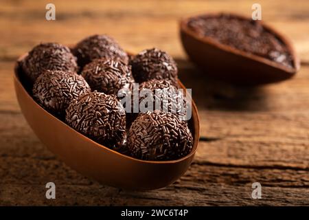 Chocolate Easter eggs stuffed with brigadiers on rustic wooden background. Stock Photo