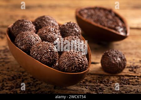 Chocolate Easter eggs stuffed with brigadiers on rustic wooden background. Stock Photo