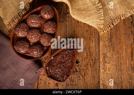 Chocolate Easter eggs stuffed with brigadiers on rustic wooden background. Stock Photo