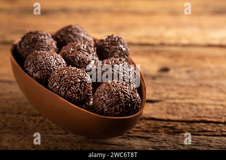 Chocolate Easter eggs stuffed with brigadiers on rustic wooden background. Stock Photo