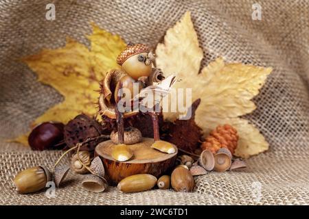 Autumn crafts. Children's fall crafts and creativity, Gnome made from acorn and chestnut on dry stump. Ideas for children's art, hometime hobby. Horiz Stock Photo