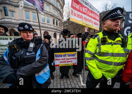 London, UK. 14th Jan, 2024. A counter protest by orthodox anti-zionist Jews is surrounded and has to be protectect by a police buffer as one of their banners is torn down - Stand with Israel Rally Trafalgar Square, marking 100 days since the attacks of October 7th. To demand the immediate release of the more than 130 hostages still held in captivity in Gaza. Organised by many groups including the Board of Deputies of British Jews. The campaign us the hashtag #BringThemHome. Credit: Guy Bell/Alamy Live News Stock Photo