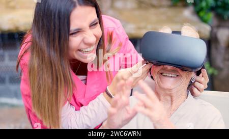 Elder woman gesturing while using virtual reality goggle in geriatric Stock Photo