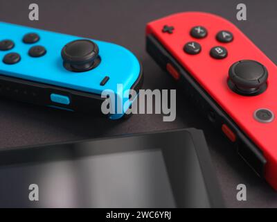 Tambov, Russian Federation - January 14, 2024 A Nintendo Switch console with detached joy-cons lying on a black surface. Close up. Stock Photo