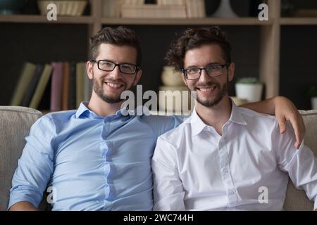 Millennial twins brothers smiling, looking at camera posing indoors Stock Photo