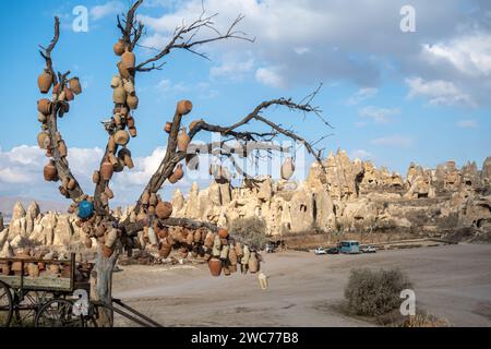 Jars on a tree a popular photography spot in Goreme Cappadocia and old wagon full of clay pots, Cappadocia in Turkey. Clay pots tree Stock Photo