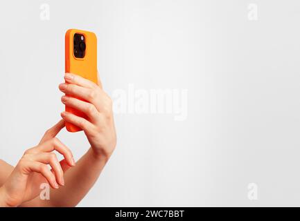 Berlin Germany December 21 2023 Hand holding iphone, taking mobile phone photo. Banner background Stock Photo