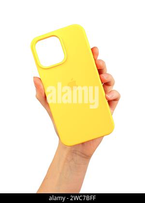 Berlin Germany December 21 2023 Yellow phone case in hand. Silicon protector isolated on white Stock Photo