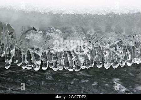 Interesting shaped icicles in frozen river. Beauty of winter weather. Czech republic nature in winter. Stock Photo