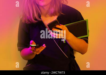 Communication with the client using two phones at the same time. Young woman in uniform communication with the client by phone. Stock Photo