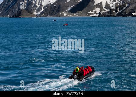 Zodiac navigating the waters near Cape Lookout and Rowett Island, Elephant Island, South Shetland Islands, on a rare sunny day in Spring Stock Photo