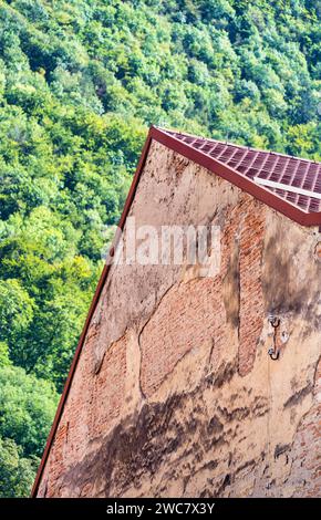 Close up detail with a old medieval red bricks wall. Peeling off building in the old town of Brasov, Romania Stock Photo
