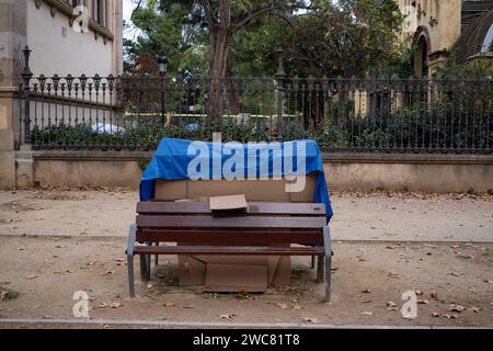 Barcelona, Spain. 14th Jan, 2024. Cardboards and personal objects of a homeless person are seen linked to a public bench in the vicinity of the Ciutadella park in Barcelona. 1,384 homeless people and 114 tents are the figures shown in the latest report of the count of homeless people sleeping on streets and parks. On December 13 the Arrels Foundation in Barcelona specialized in assisting and guiding to people who live on the streets of the city carried out a report on homeless people. (Photo by Paco Freire/SOPA Images/Sipa USA) Credit: Sipa USA/Alamy Live News Stock Photo