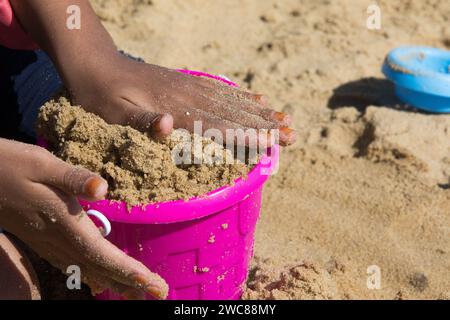 Pink sand pail and shovel on a beach Stock Photo