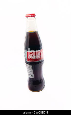 Imported Mexican Coca-Cola bottle isolated on a white background with additional nutrition facts label added for importation Stock Photo
