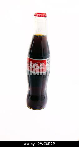 Imported Mexican Coca-Cola bottle isolated on a white background with additional nutrition facts label added for importation Stock Photo