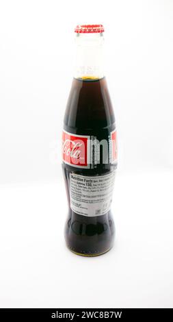 Imported Mexican Coca-Cola bottle isolated on a white background with additional nutrition facts label added for importation Stock Photo
