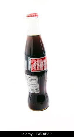 Imported Mexican Coca-Cola bottle isolated on a white background with additional nutrition facts label added for importation Stock Photo