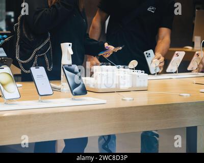 Paris, France - Sep 22, 2023: A customer discusses the newest Apple computers and iPhone Pro models with a store employee during an exciting product launch event Stock Photo