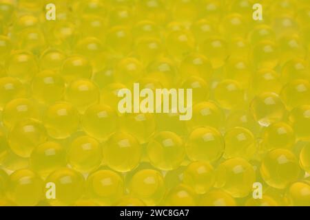 Closeup view of yellow vase filler as background. Water beads Stock Photo