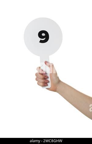 Woman holding auction paddle with number 9 on white background, closeup Stock Photo