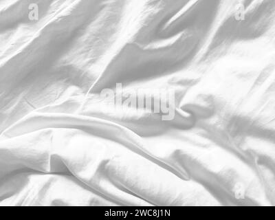 A pristine white fabric background showcasing the luxurious texture of silk, creating an abstract and soft ambiance perfect for a high-end design. Stock Photo