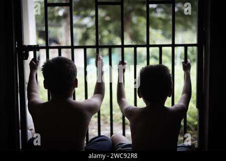 Children who were imprisoned in a room with a steel cage. The concept of stopping violence against children and human trafficking. Stock Photo