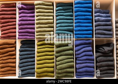 Stacks of socks and models of various colors on a store shelf. Stock Photo
