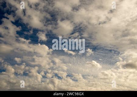 White clouds with a background of blue sky. The sun trying to break through the oval clouds like an eye in the sky. Stock Photo