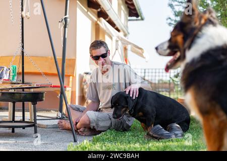 Grill with raw meat on it. There are cevapcici, burger patty's for grilling. It was summer and bbq picnic time. The food is cooked in the garden. Stock Photo
