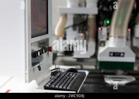 Computer controlled woodworking machine at furniture factory. Control console of CNC woodworking machine. Stock Photo