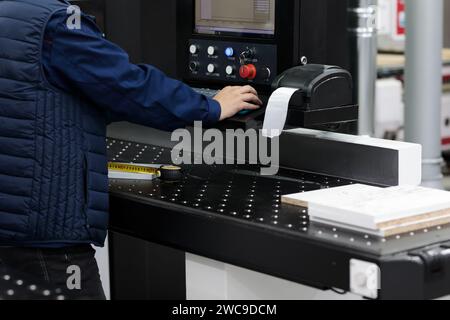 Factory worker labeling barcode shipping stickers. Thermal barcode shipping label sticker printer at furniture factory. Selective focus. Stock Photo