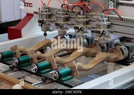 Table legs carving with multi heads furniture engraving CNC router machine. Selective focus. Stock Photo