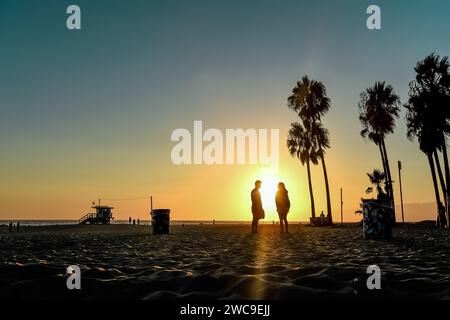 Silhouettes of Lovers by Sunset on the Sands of Venice Beach, California Stock Photo