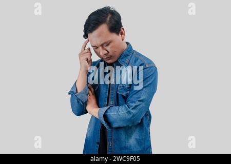 Young Asian Man thinking about questions with pensive face expression on isolated background Stock Photo