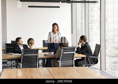 Positive motivated young Black business professional holding meeting with team Stock Photo