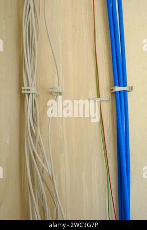 Electric cable and network cable at a wall Stock Photo