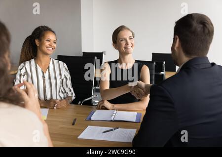 Happy successful diverse female managers discussing successful project Stock Photo