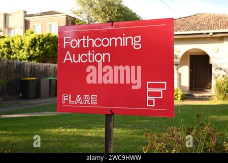 Red forthcoming auction sign, from the locally based Flare Real Estate company, in the front yard of a suburban home Stock Photo