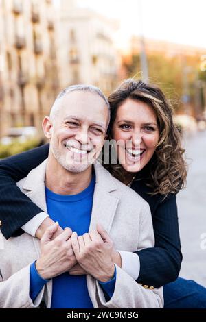 Affectionate mid adult woman hugging handsome man having fun together in a romantic date. Lovely mature couple bonding together . Stock Photo