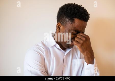 Portrait of young businessman who is tired and having headache. Stock Photo