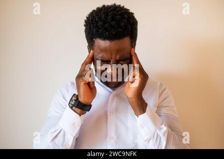 Portrait of young businessman who is tired and having headache. Stock Photo