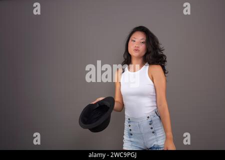 Young Chinese lady stylishly presents a hat Stock Photo